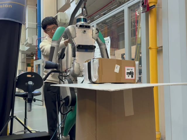 The team troubleshoots a robot interaction at a worktable.