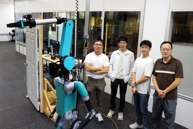 Four team members beside the humanoid and its raised neck-mounted SRL.