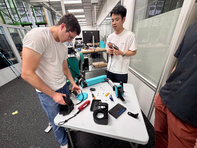 The team repairs the detached SRL at the workbench.